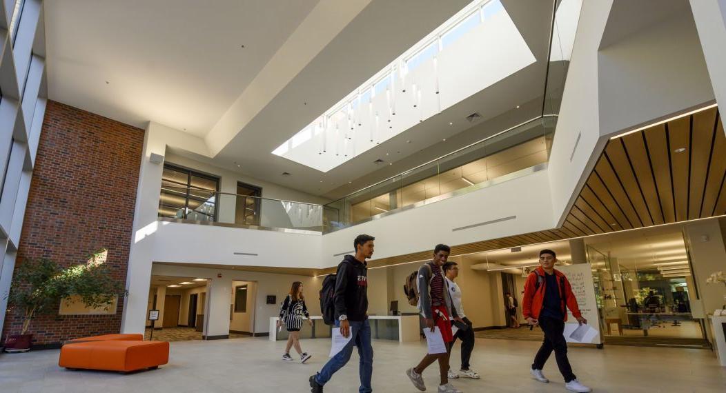 students walk in the lobby of the library